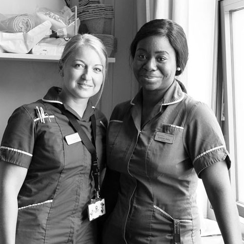 Black and white shot of two smiling midwives