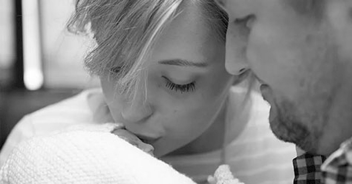 Close up of woman kissing tiny baby